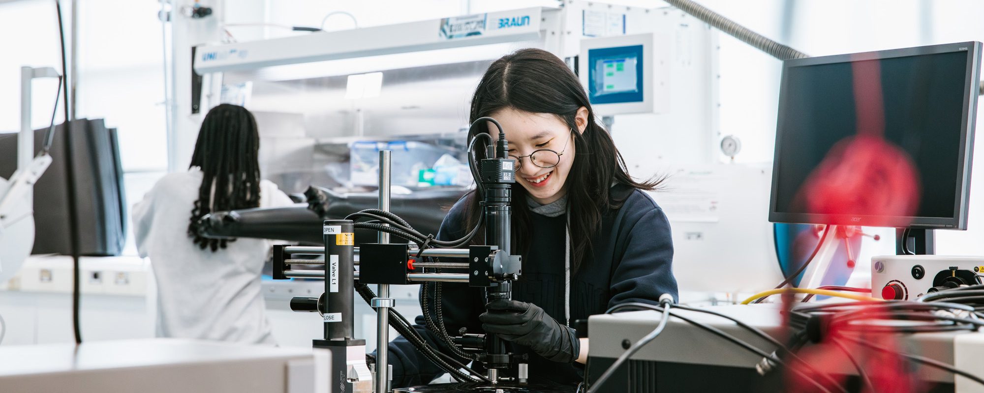 Female student smiling with lab equipment