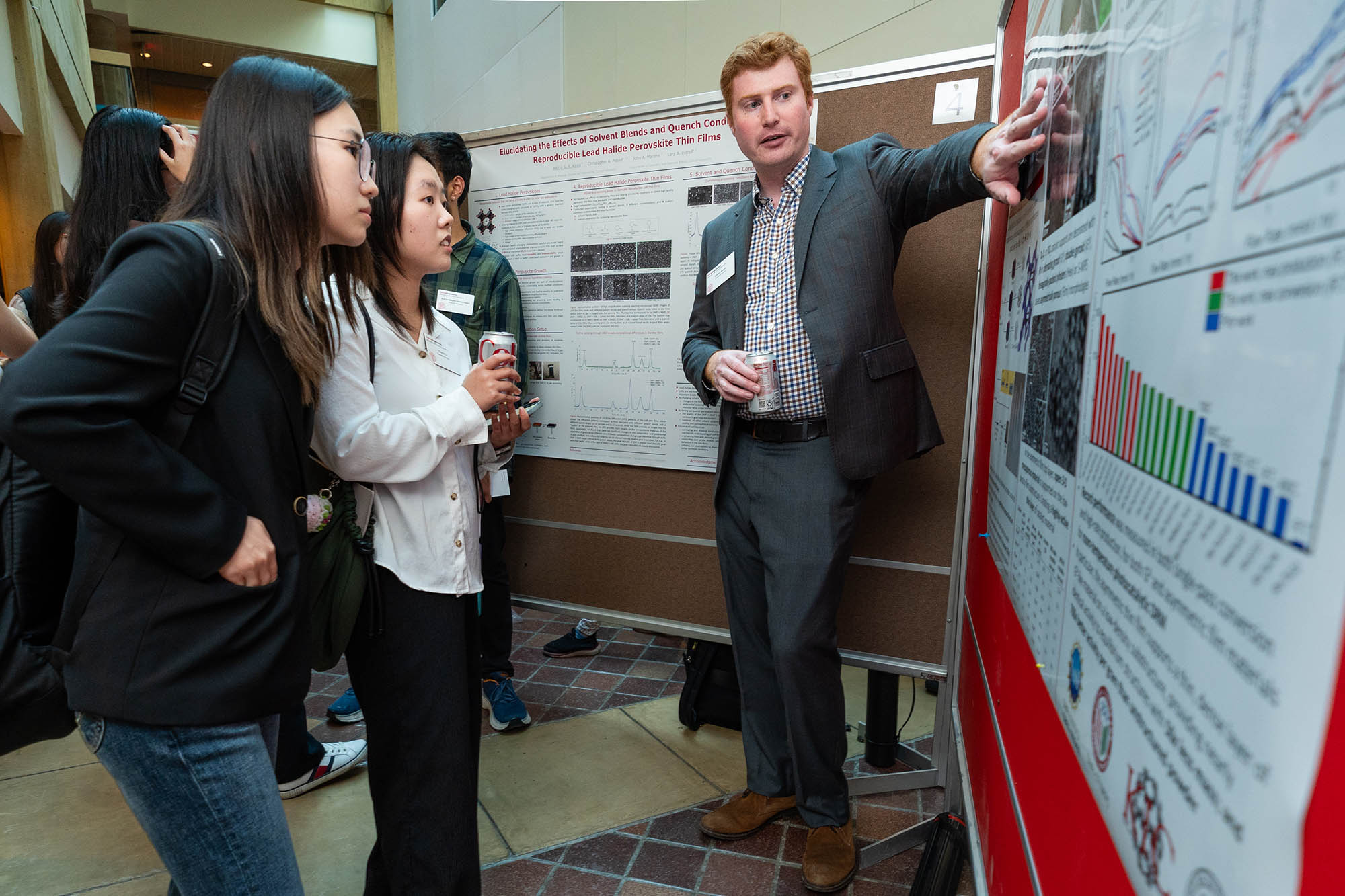 Student presenting to a group in front of a poster board