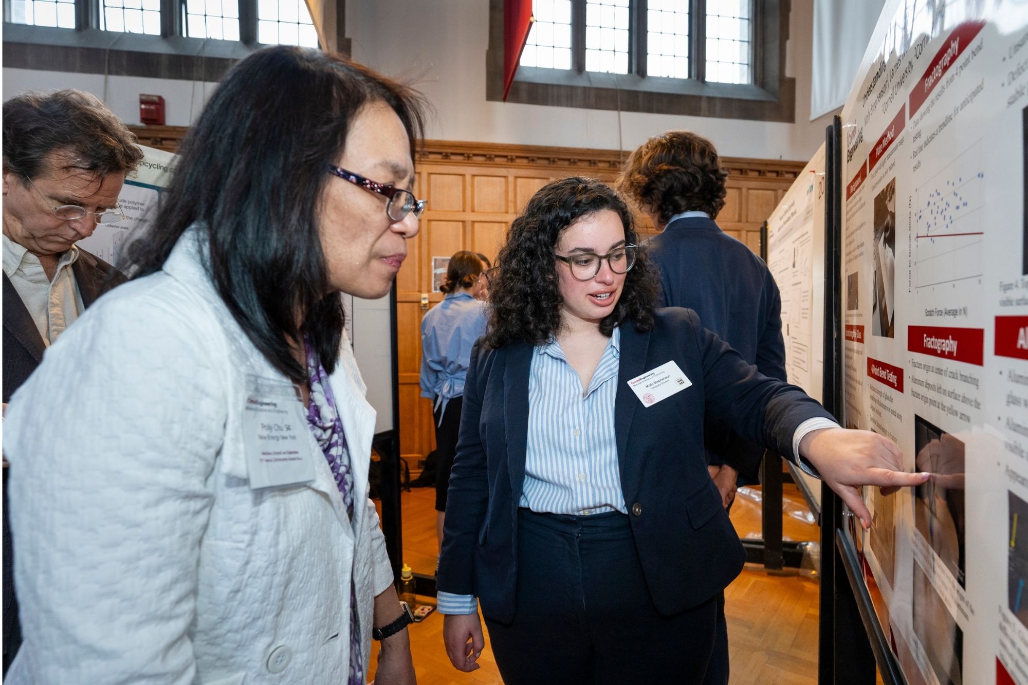 Student presenting research to a community member during a poster session