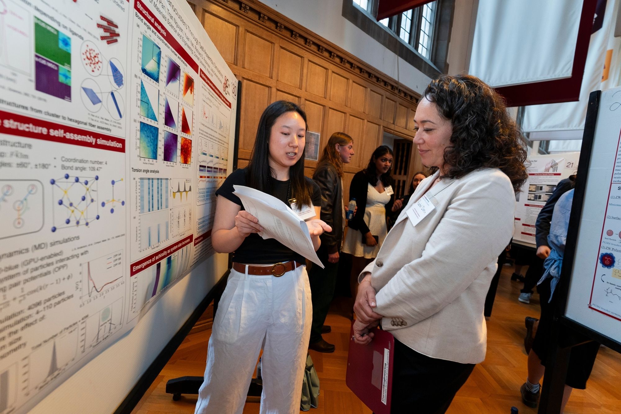 Rachel Dorin talking with a student during the 2025 awards gala and research symposium