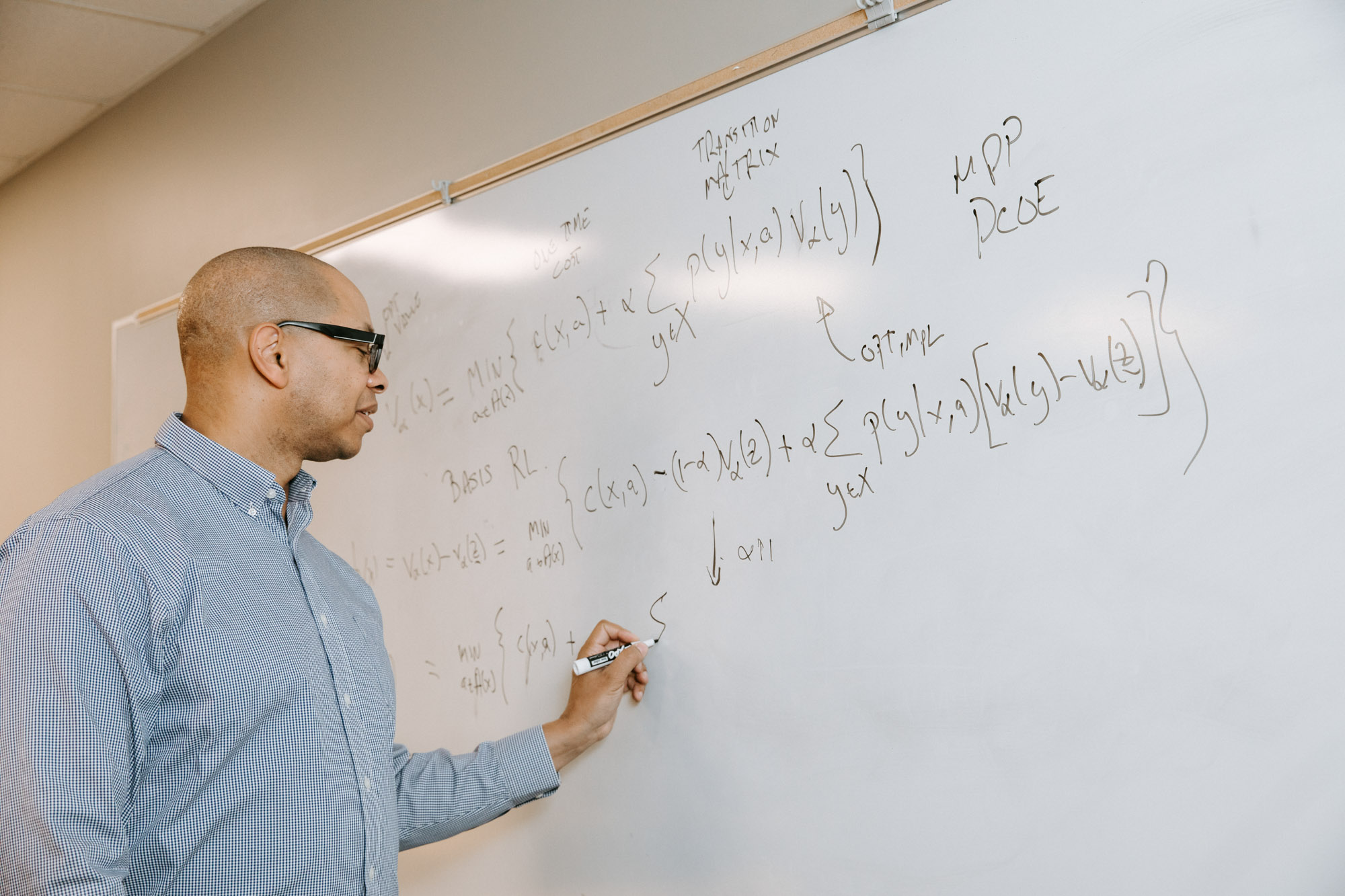 ORIE Professor Mark Lewis writes on a whiteboard
