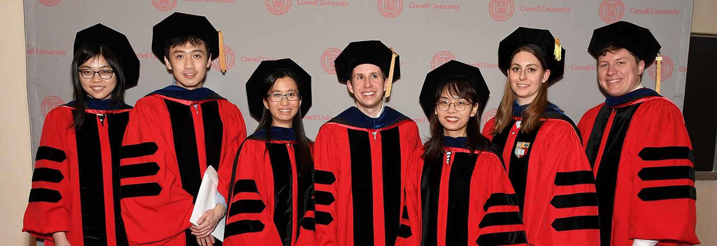 Seven ORIE graduates in caps and gowns