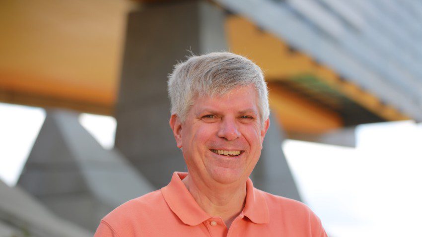 David Williamson smiles in front of Cornell's Gates Hall.