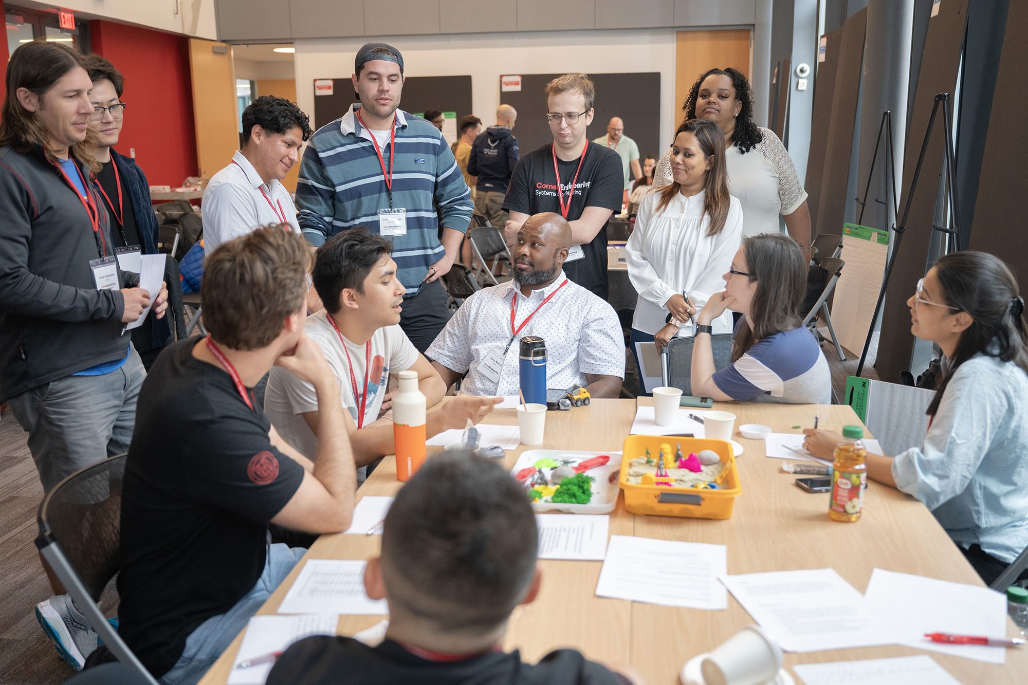 A group of students sit around a table discussing something,
