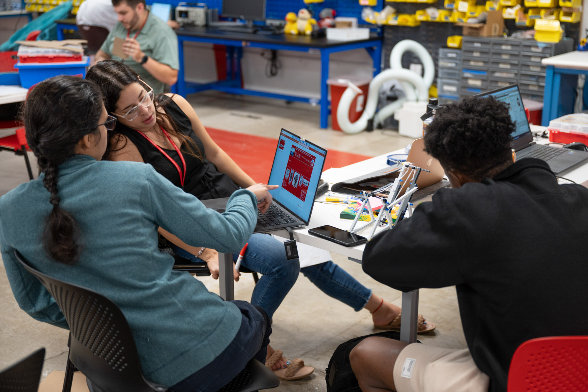 Three distance learning students work at their laptops in the Carpenter Lab during SYSEN 5920