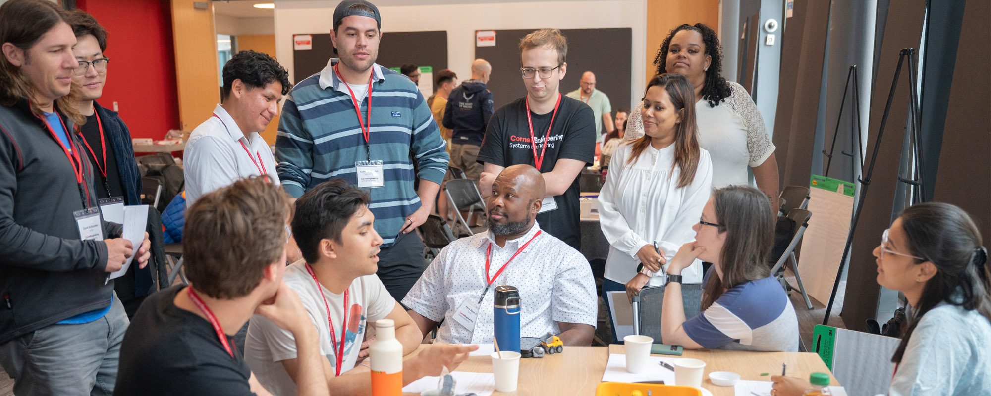 A group of students sit around a table discussing and working on a problem.