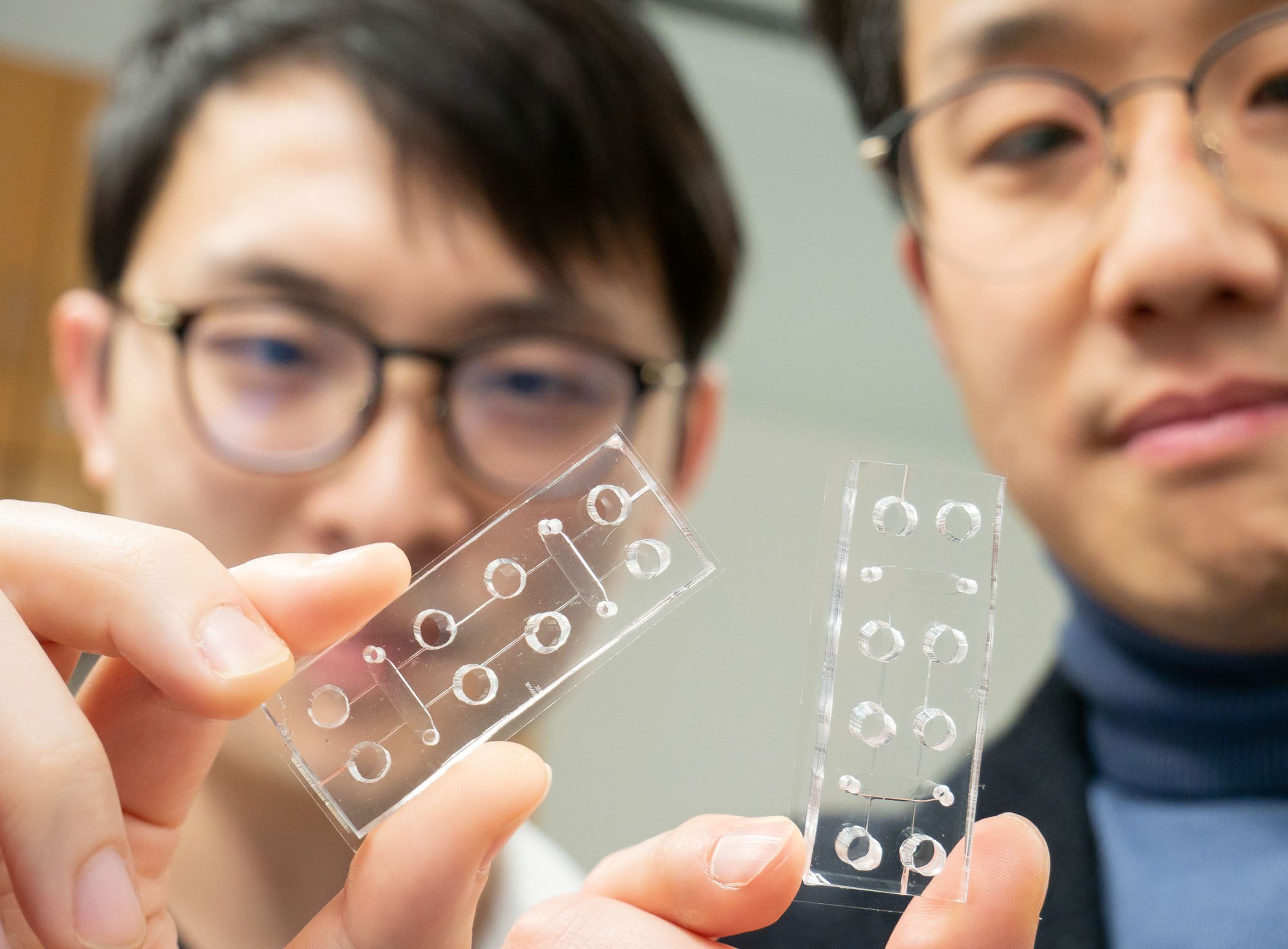 Esak Lee and student each hold 3D organs-on-chip in vitro platforms
