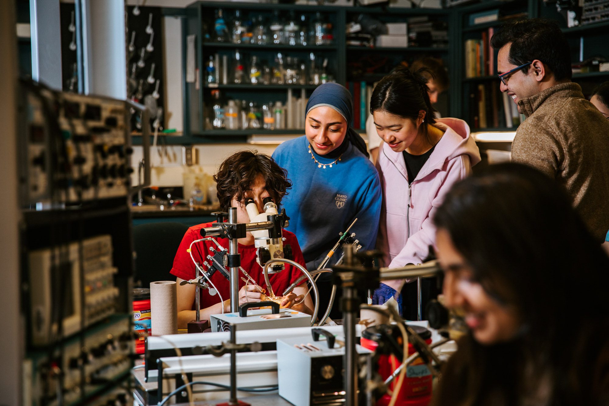 Students gather around professor in lab
