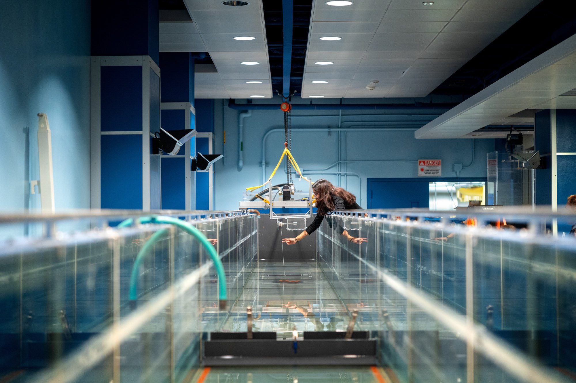 Long shot of student Kavya Mittha testing their wave energy conversion machine in the wave simulator tank in Hollister Hall.