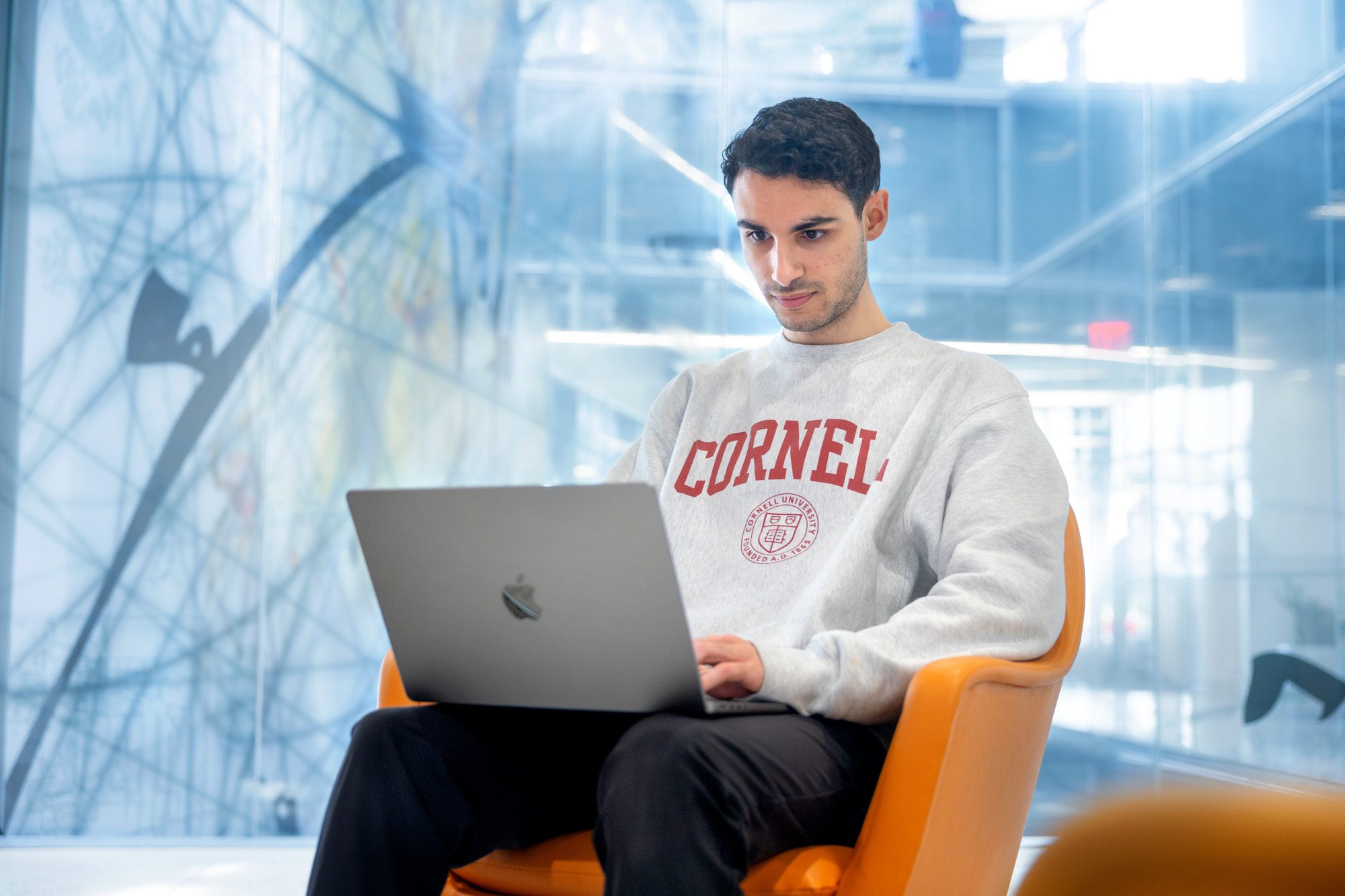 A student works on their computer at Cornell Tech