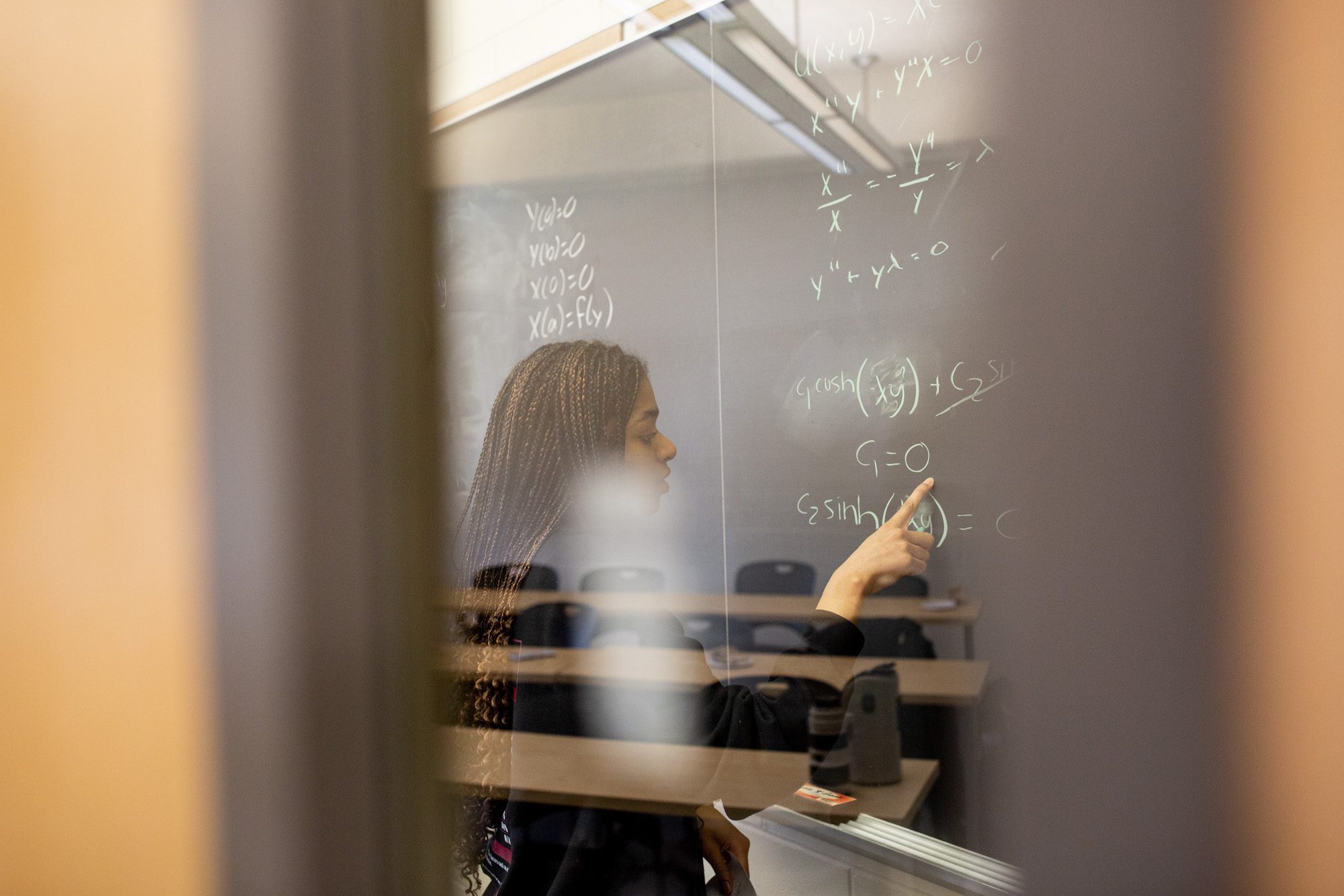 Students work on equations at a chalkboard during an Academic Excellence Workshop