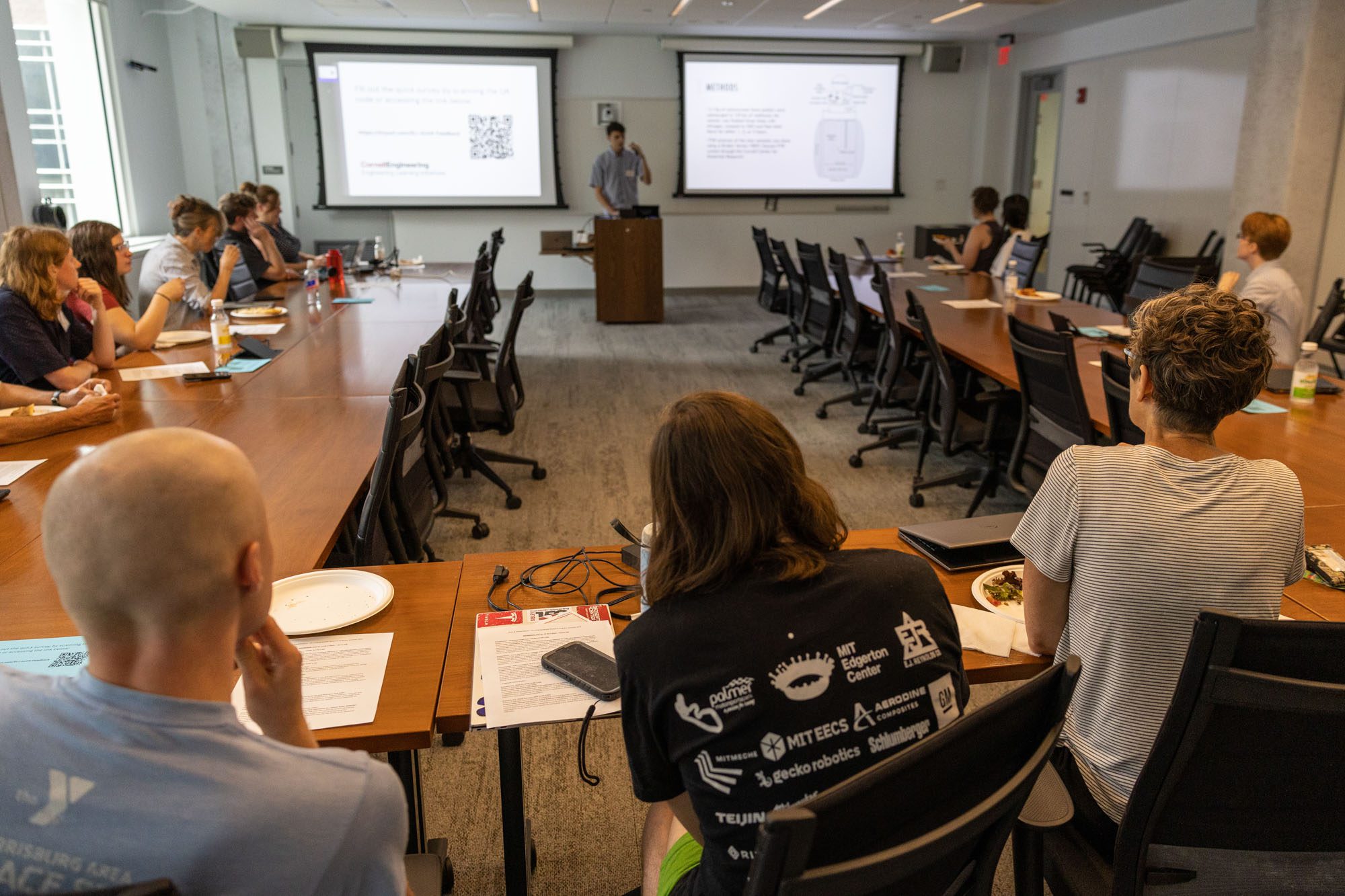 An undergraduate student gives a research presentation in a large conference room