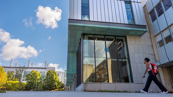 Student walking in front of Tang Hall