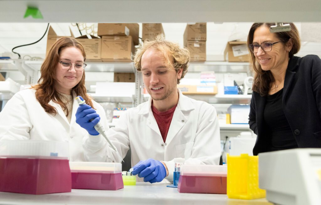 Claudia Fischbach observes researchers working with test tubes