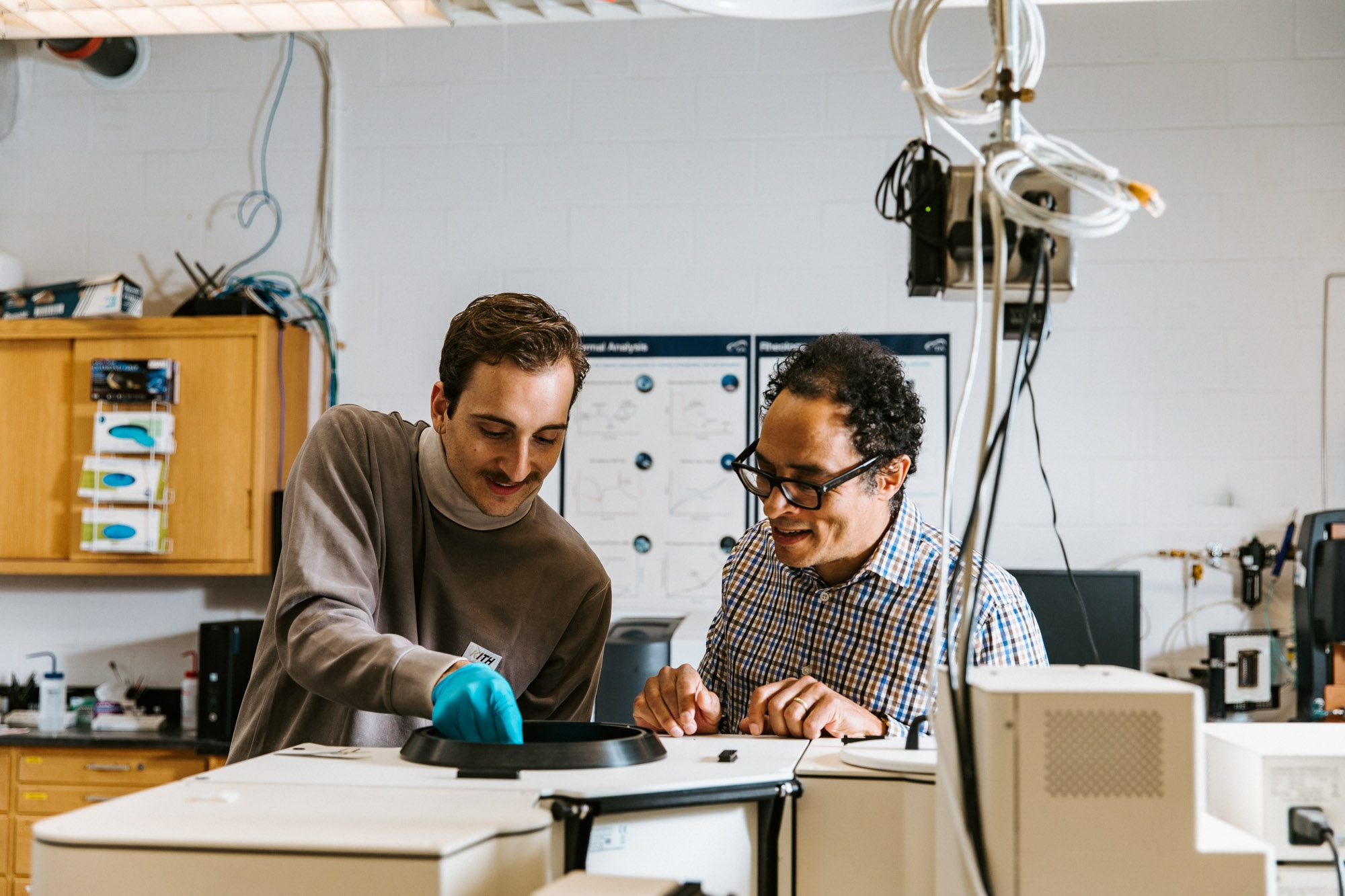 Two researchers work together at device