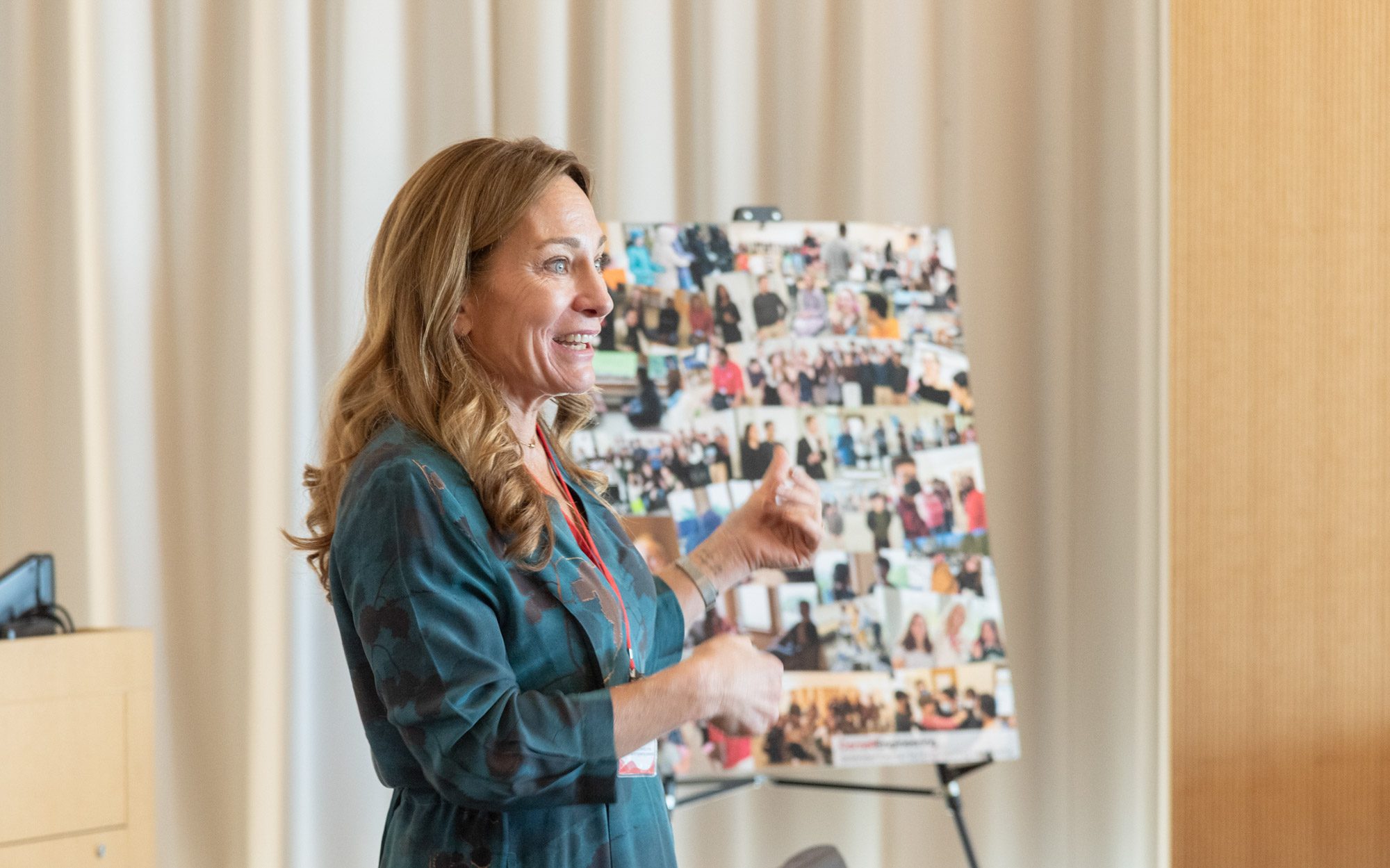 Erica Dawson speaks to audience and points to poster of image collage