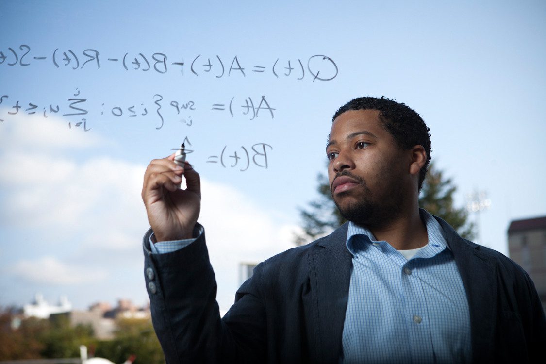 Jamol Pender writes equations on glass wall