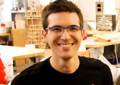 Male student smiling with construction projects in the backrgound