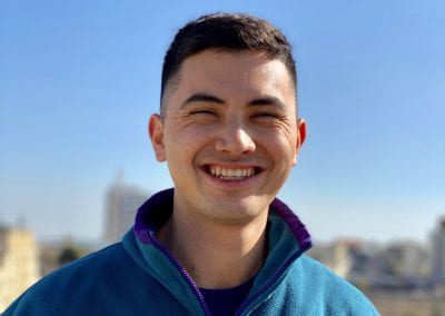 Male student smiling outside in the sun