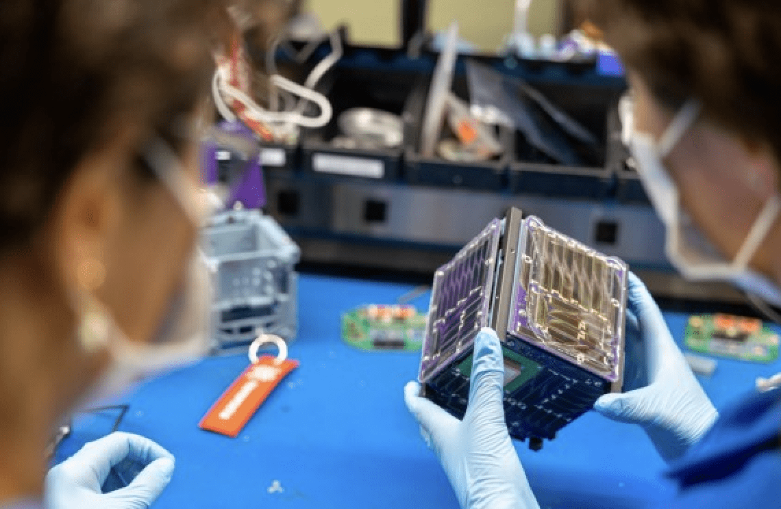 The Padres sisters examine Alpha CubeSat (a light sail-carrying, cube-shaped satellite) in the Space Systems Design Studio Lab in Rhodes Hall.