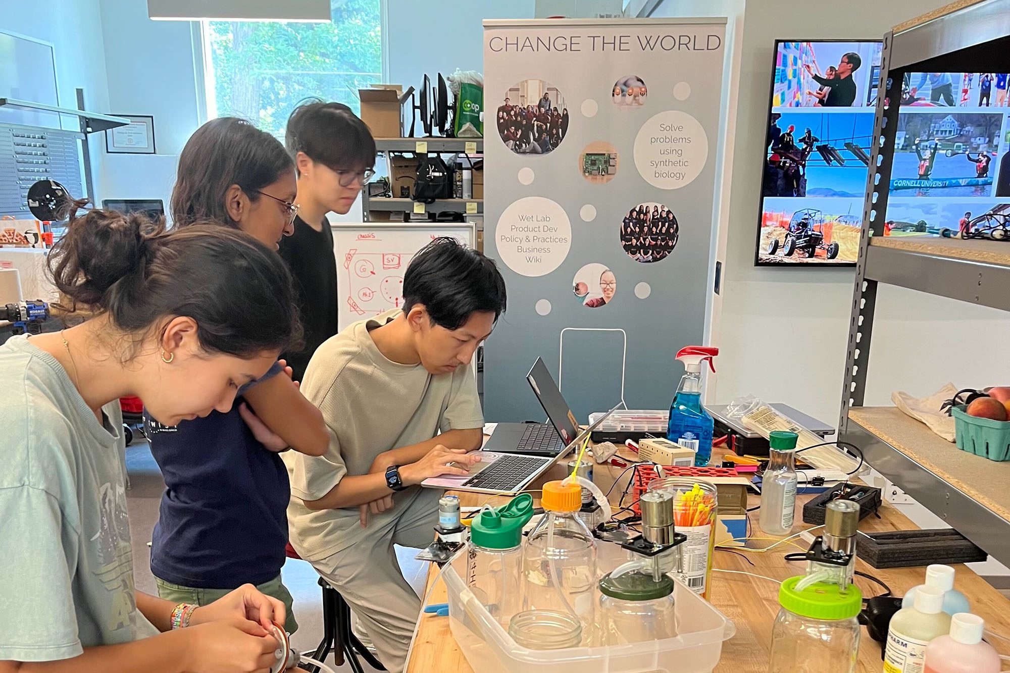 Students gather around a work table