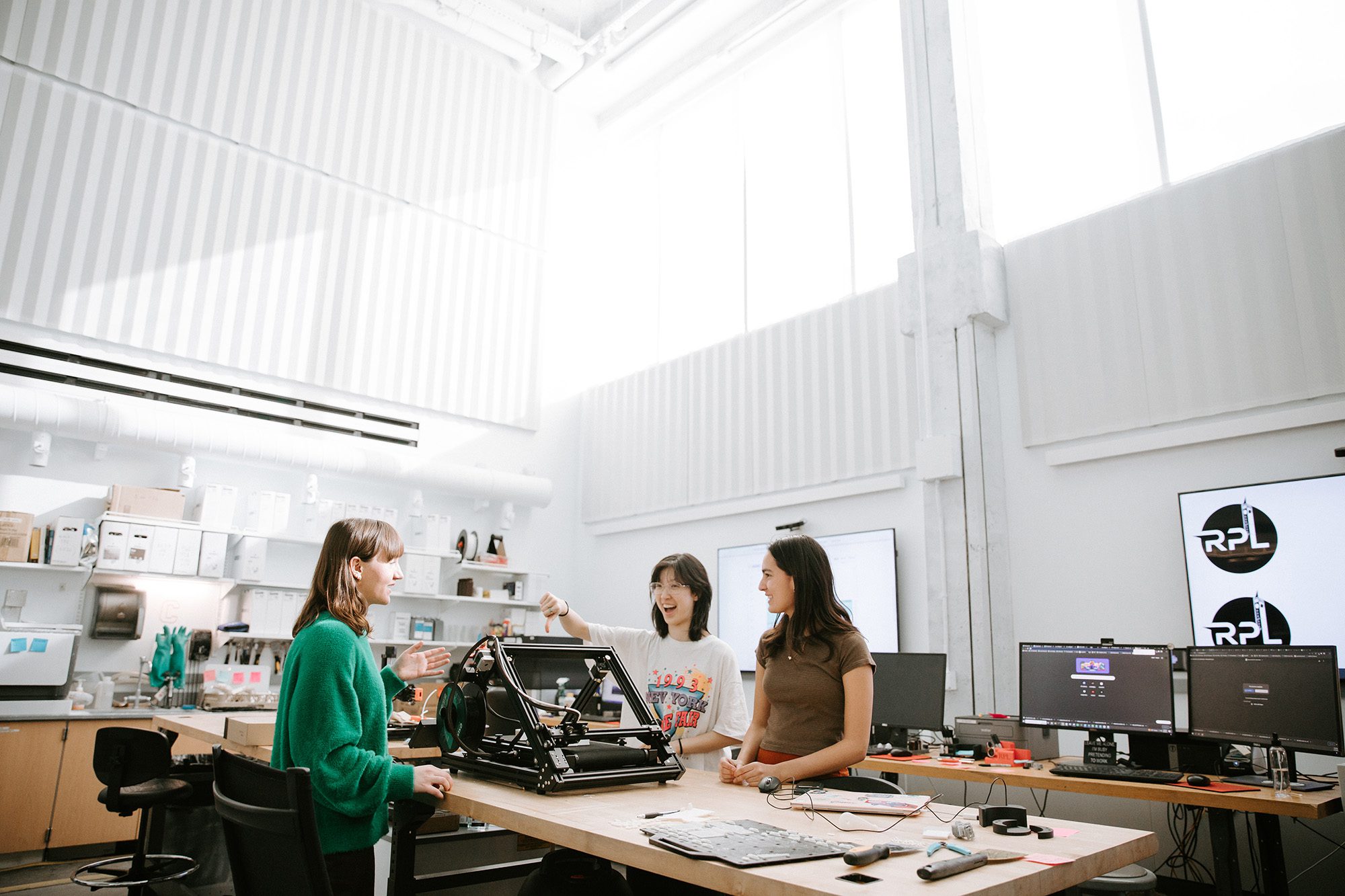 Students work together around a table in the Rapid Prototyping Lab