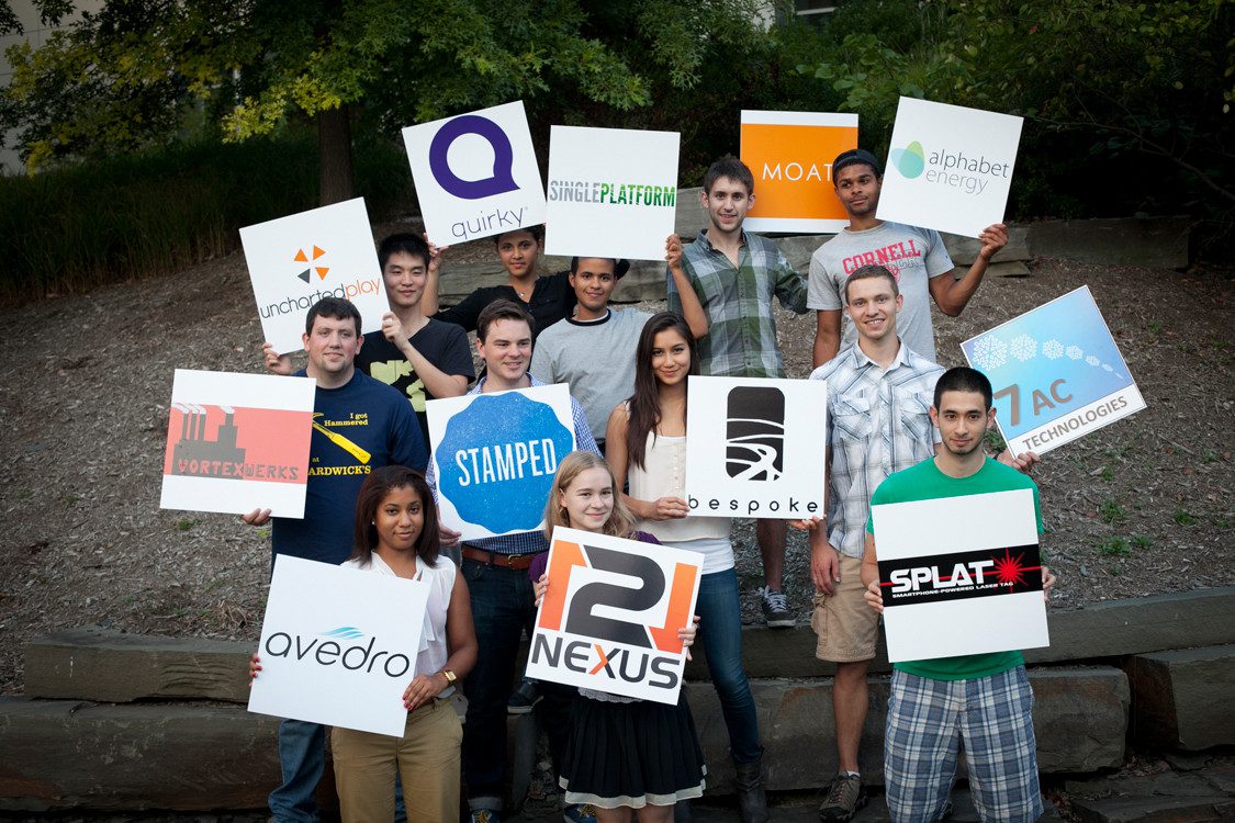 Entrepreneurship students holding signs with company logos