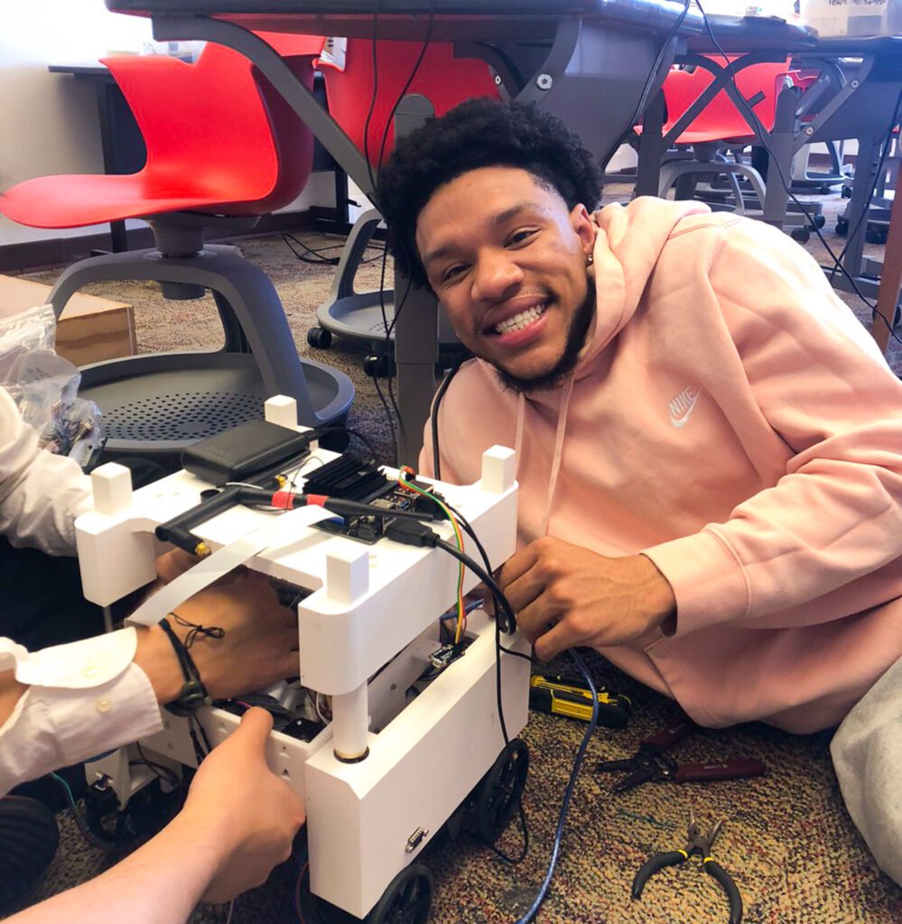 student hold robot on the ground