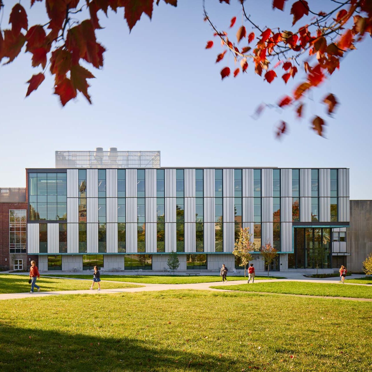 Tang Hall with students walking in front on the sidewalk in the engineering quad.