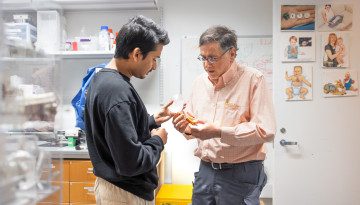 two researchers examine a small device