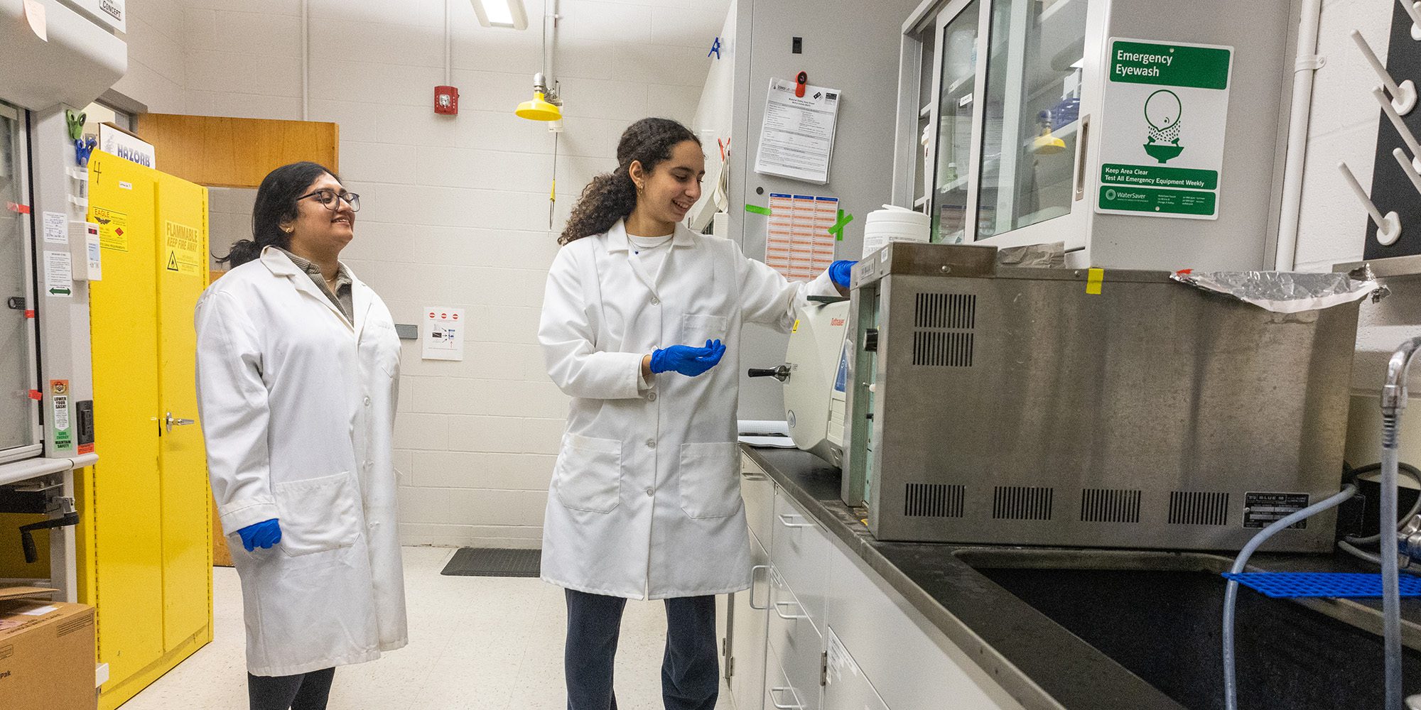 Undergraduate researchers Asher and Zaina work together in the lab.