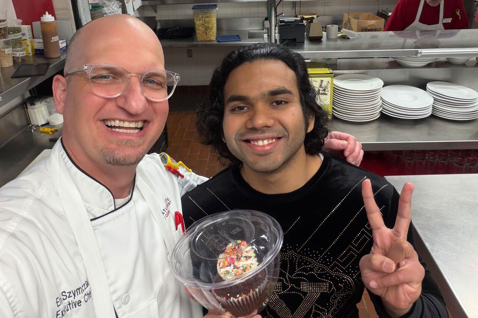 CBE M.Eng. Student Siddhant Dhende in the Taverna Banfi kitchen with main Banfi chef Eric Szymczak and cupcake.