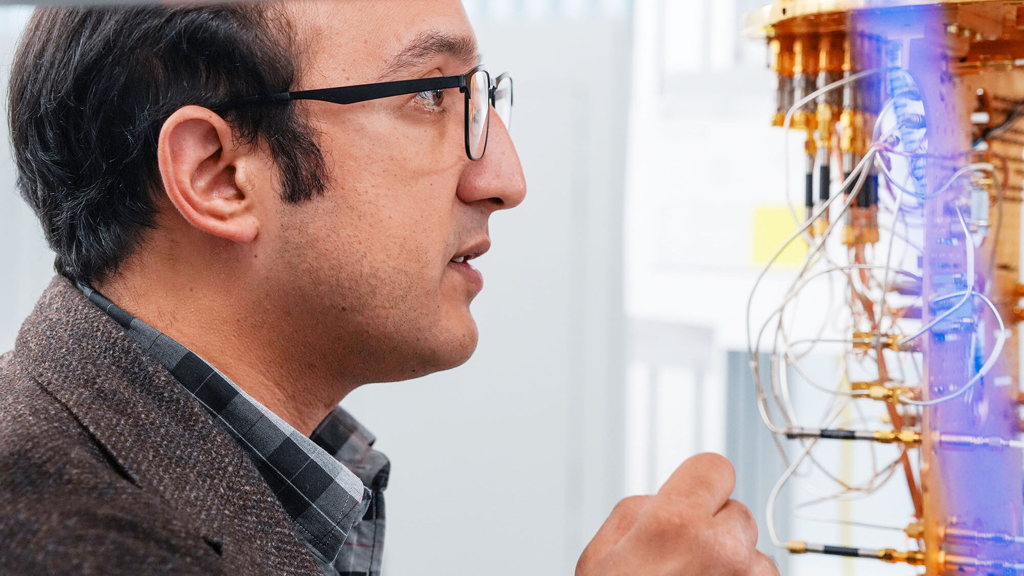 Profile view of a man looking at the inside of a cryostat