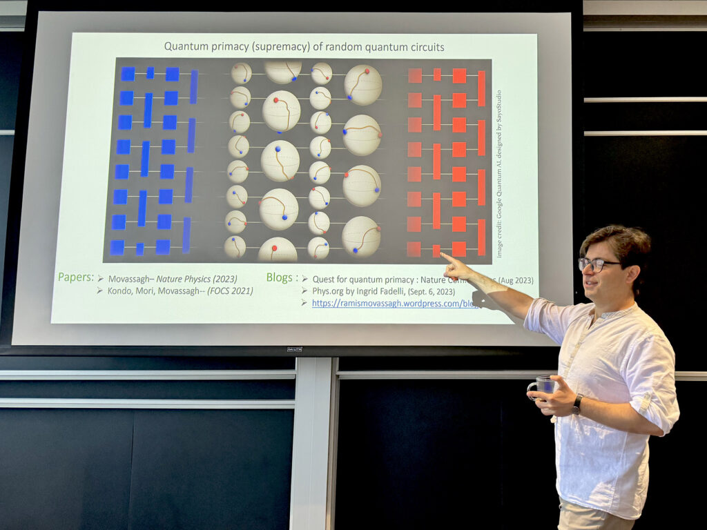 Ramis Movassagh '04 stands in front of a projected slide that has the topic "quantum primacy of random quantum cirdcuits"