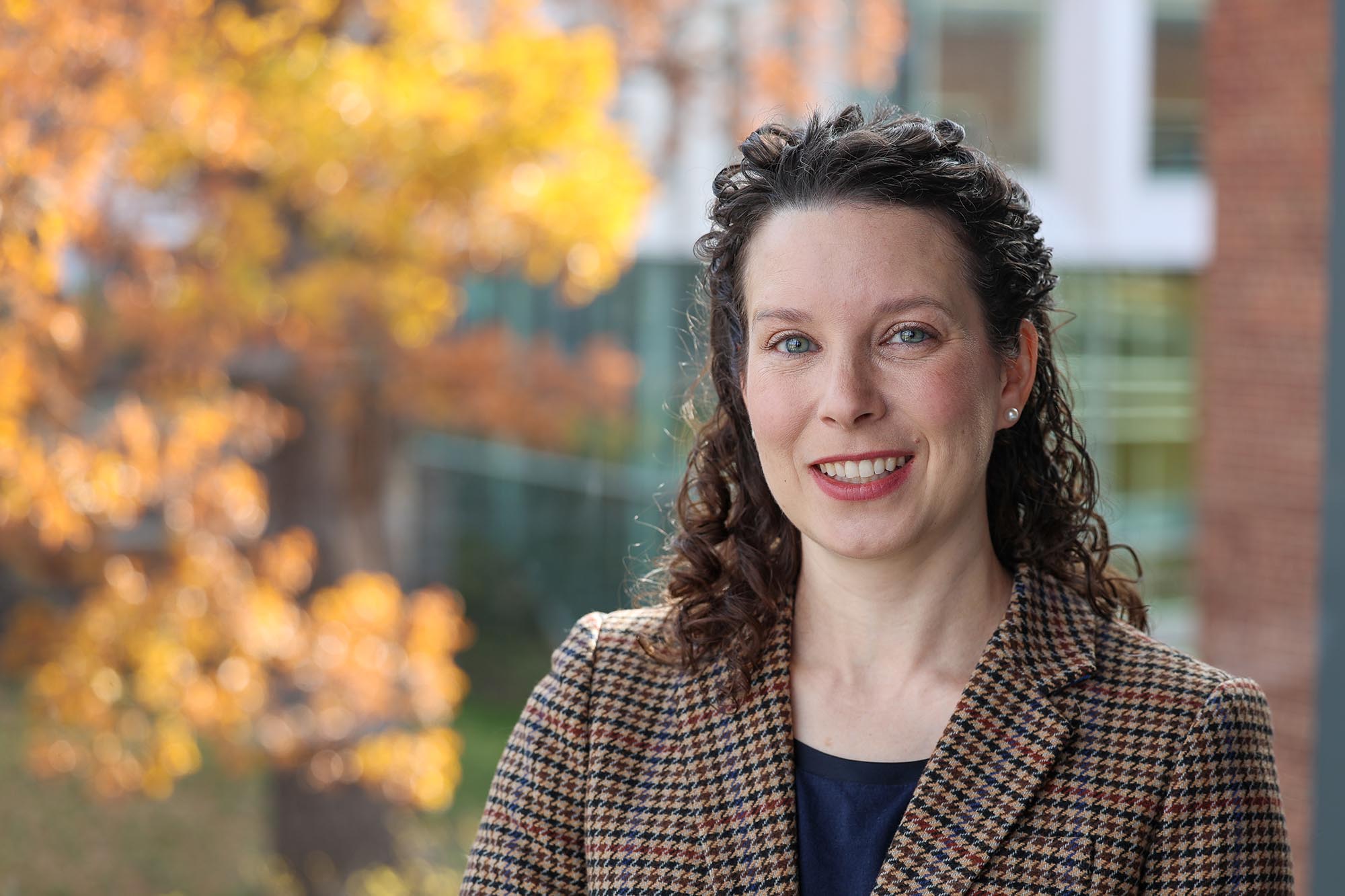 Allison Godwin smiling with autumn leaves blurry background