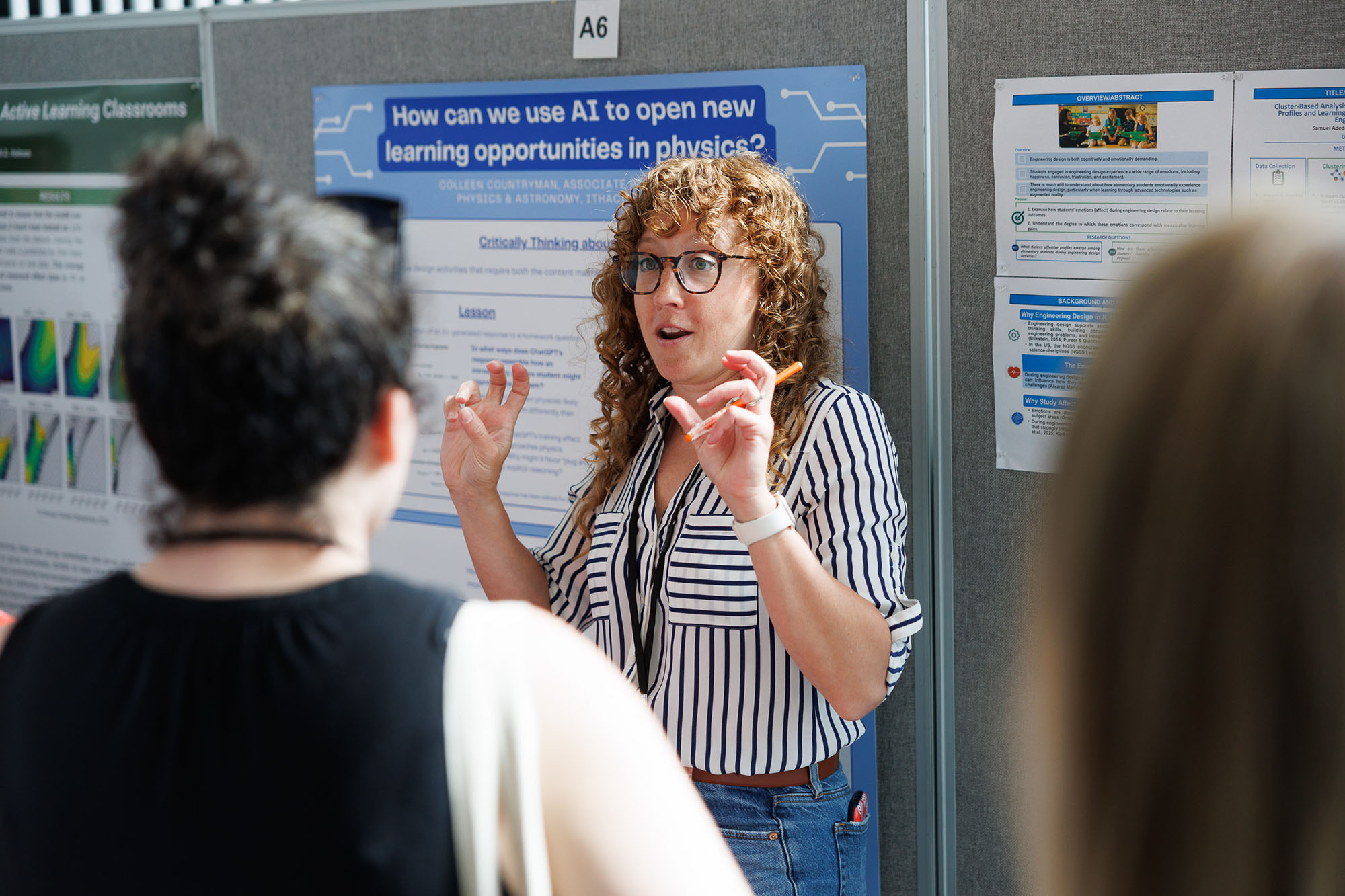 A woman chats with participants in front of a poster presentation at the NYDBER meeting in Weill Hall, June 2026.