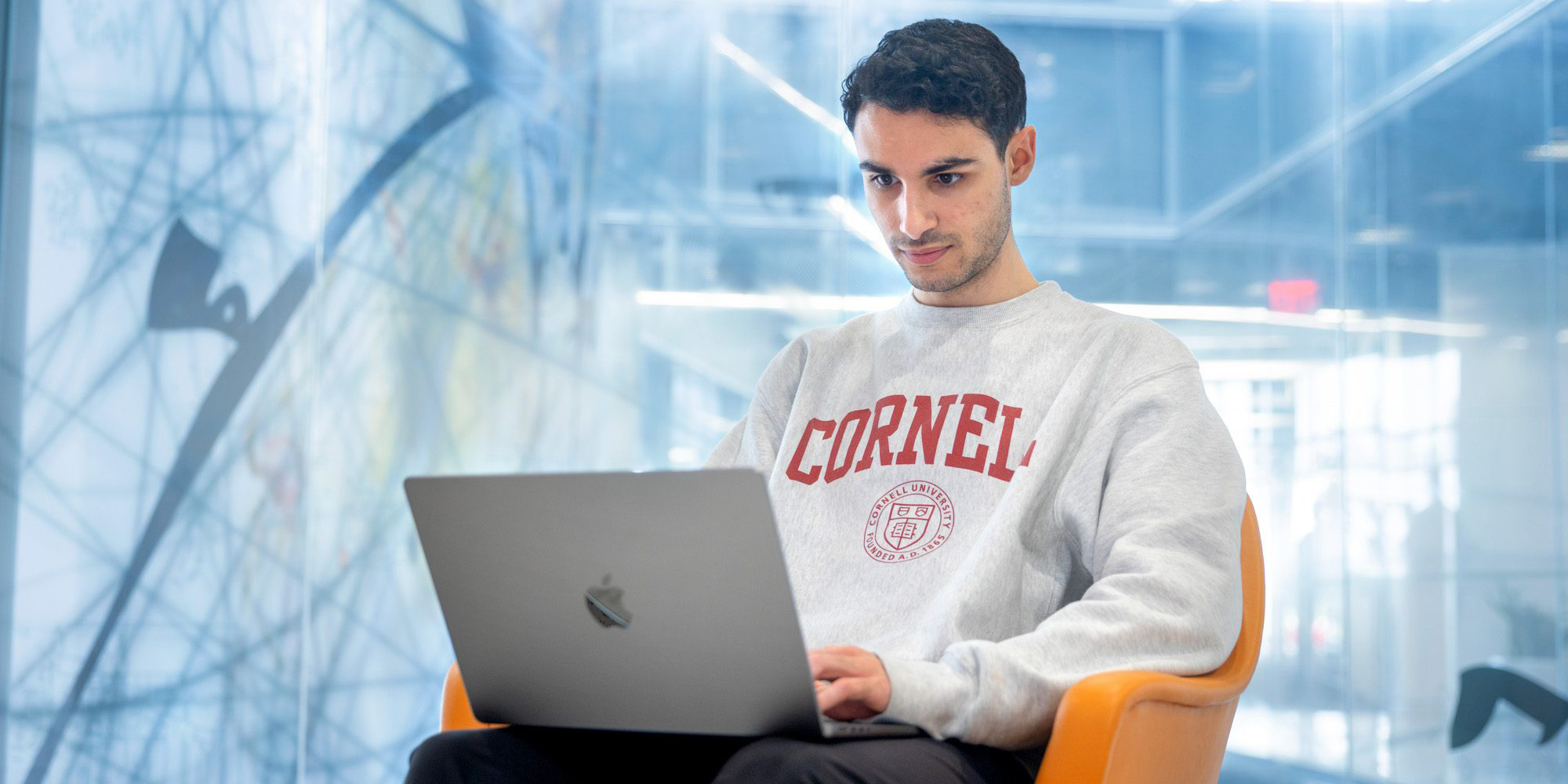 A student works on their computer at Cornell Tech